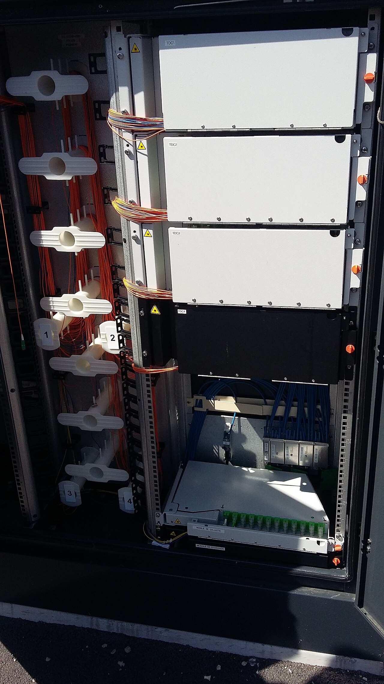 L’intérieur d’une armoire de rue de fibre optique, avec ses câbles.