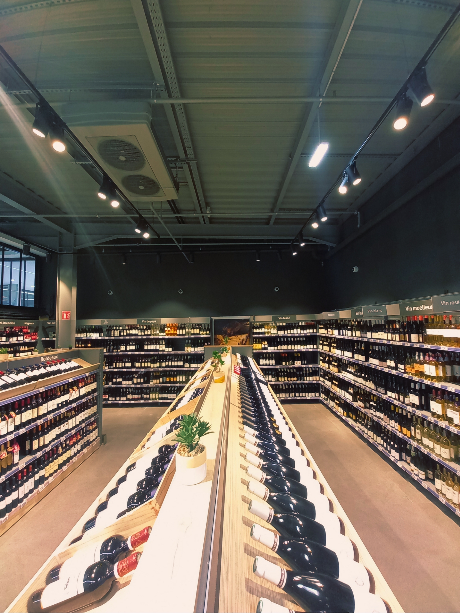Un rayon de grande surface en France, bouteilles et packs alignés.